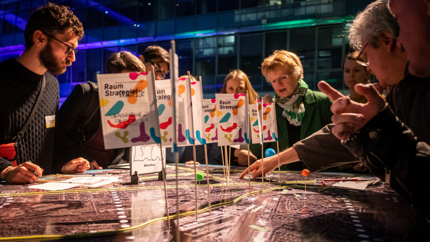 Die Luftbilder auf den Arbeitstischen waren am Ende der Workshops gespickt mit bunten Markierungen und beschrifteten Fähnchen, auf denen die Ideen vermerkt wurden. Die Anmerkungen werden ausgewertet und fließen in die weitere Arbeit an der BerlinStrategie ein.