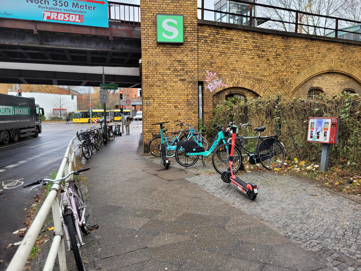 Wild abgestellte E-Roller und Fahrräder am Geländer am S-Bahnhof
