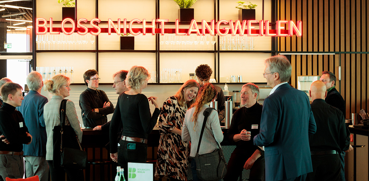 Personengruppe an der Bar bei der Solarcity-Konferenz.