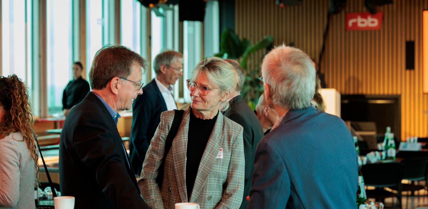 Drei Personen auf der Solarcity Konferenz unterhalten sich.